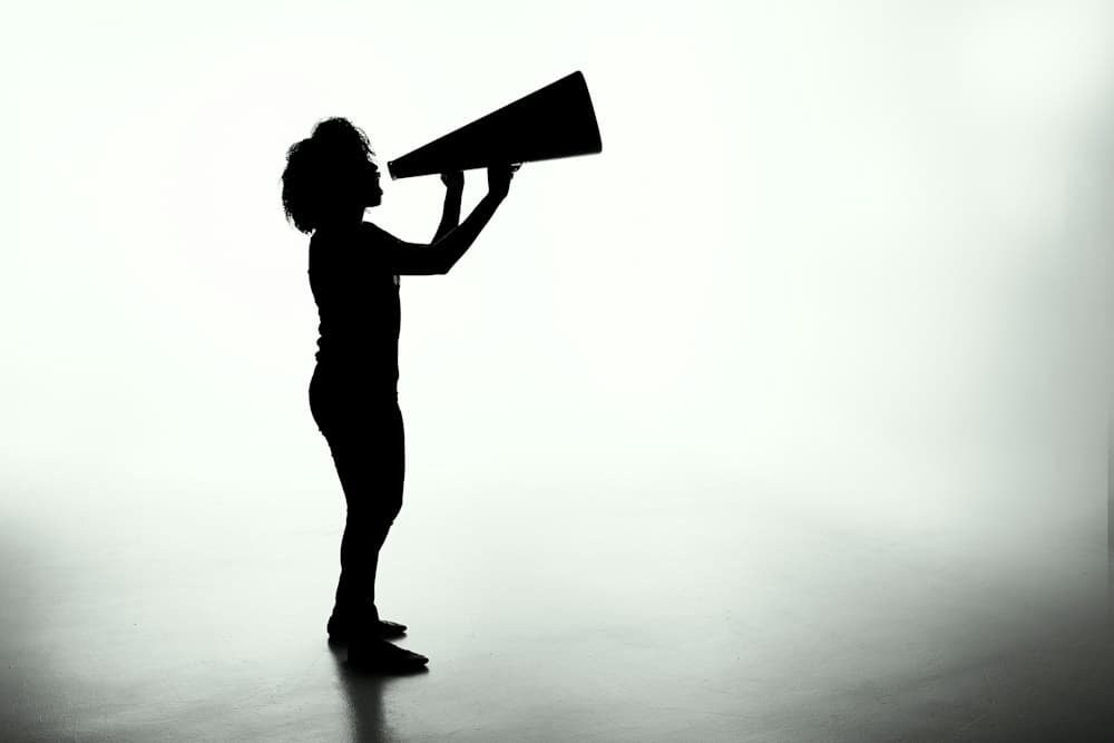 Silhouette of a person making an announcement through a megaphone
