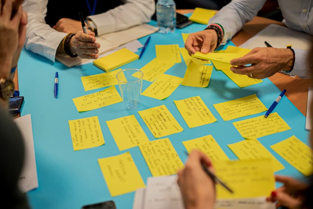 Hands sorting ideas written on sticky notes during a workshop activity