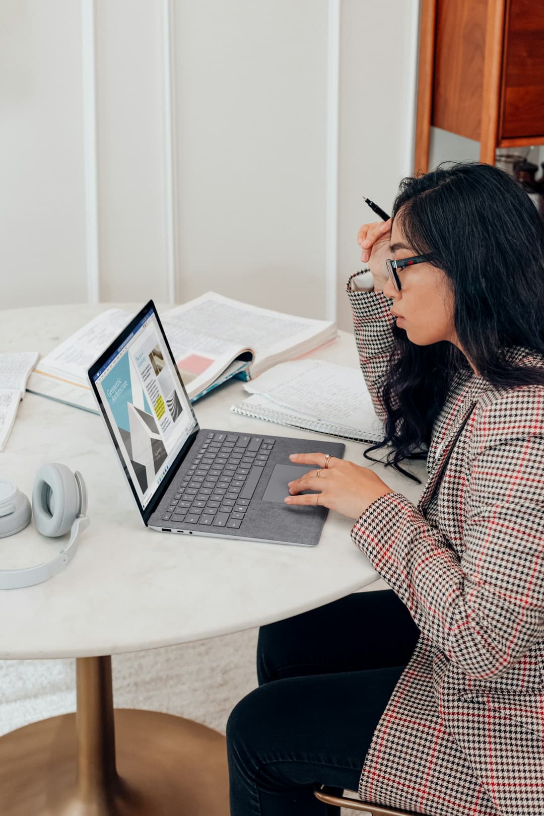 A woman taking notes at her laptop during an online workshop